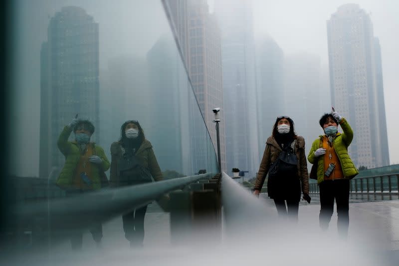 FILE PHOTO: People wearing face masks walk on a street following the coronavirus disease (COVID-19) outbreak, in Shanghai