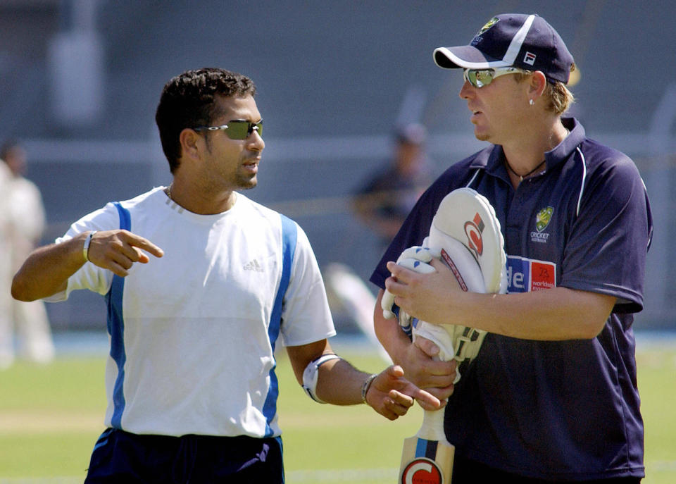 Indian batsman, Sachin Tendulkar (L) with his left arm taped because of tennis elbow, gestures towards Australian spin bowler, Shane Warne at a practice training session in Bombay, 29 September 2004.   Australia open their Indian tour with a three-day match against national champions Mumbai at the Brabourne stadium on 30 September, running up to the first Test in Bangalore on 06 October and followed by Madras, Nagpur and Bombay.      AFP PHOTO/Rob ELLIOTT  (Photo credit should read ROB ELLIOTT/AFP via Getty Images)