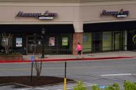 A woman walks past a closed massage parlor days before the phased reopening of businesses from coronavirus disease rules in Atlanta