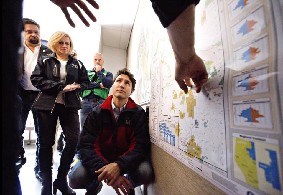 Prime Minister Justin Trudeau is given a briefing at the Regional Emergency Operation Centre during a visit to Fort McMurray, Alta., on Friday, May 13, 2016, to see first-hand the devastation caused by the wildfire that forced the evacuation of the city. THE CANADIAN PRESS/Jason Franson