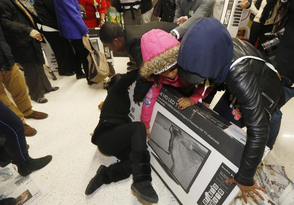 Shoppers wrestle over a television as they compete to purchase retail items on "Black Friday" at an Asda superstore in Wembley