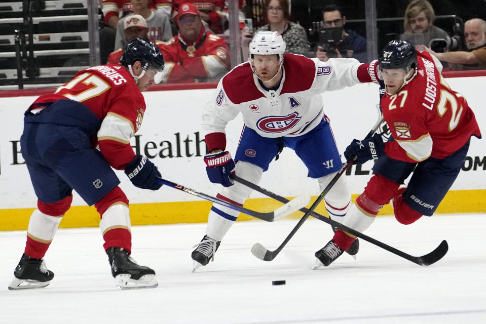 Florida Panthers center Evan Rodrigues (17), Montreal Canadiens defenseman Mike Matheson (8) and Panthers center Eetu Luostarinen (27) go for the puck during the first period of an NHL hockey game Thursday, Feb. 29, 2024, in Sunrise, Fla. (AP Photo/Lynne Sladky)