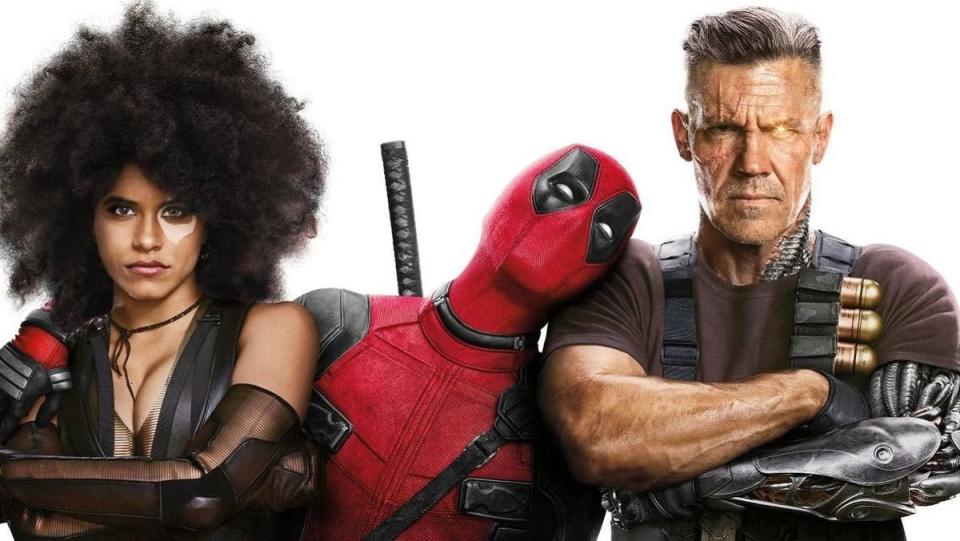 Deadpool has his arms around Domino and Cable, with his head lovingly on Cable's shoulder, while the other two look annoyed.