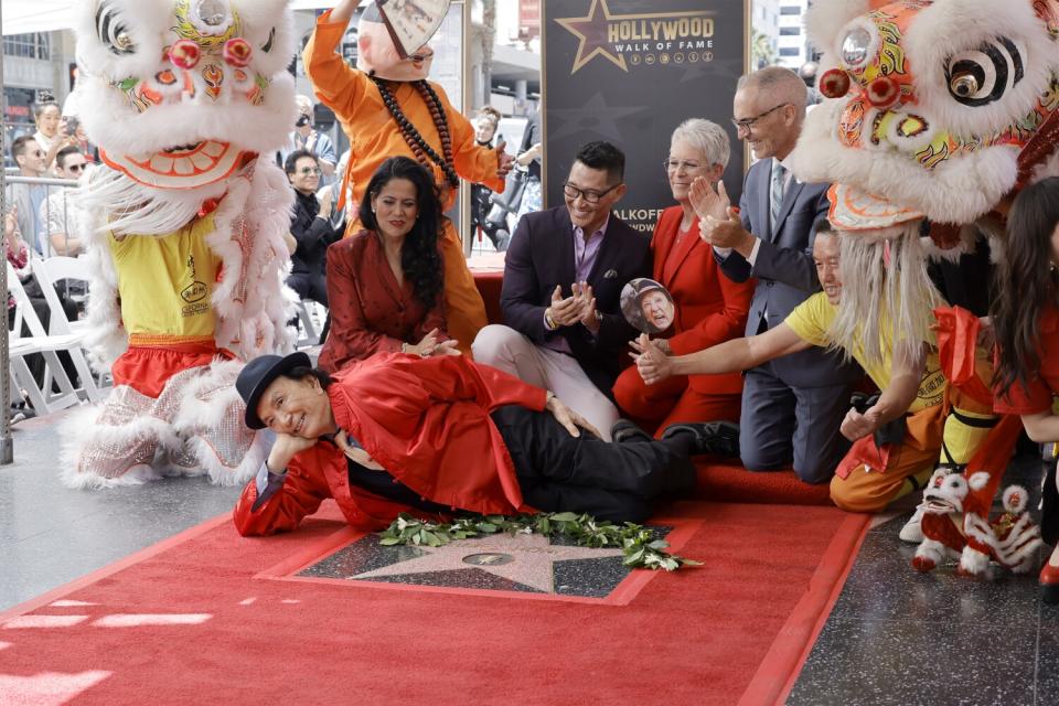 People pose for a photo on a red carpet