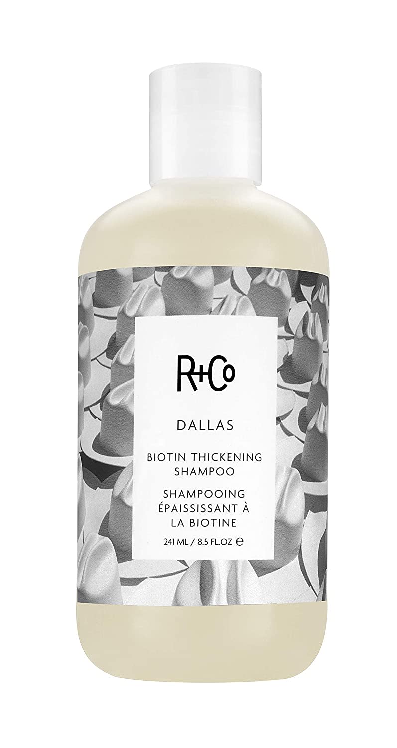 Gray, black, and white R+Co Dallas shampoo bottle