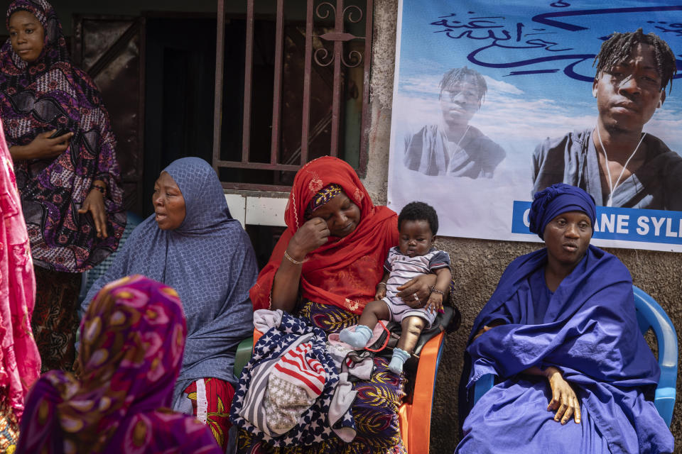 Mourners gather at the house of Ousmane Sylla's mother before her son's burial at Matoto Bonagui, a suburb of Conakry, Guinea, Tuesday, April 9, 2024. (AP Photo/Misper Apawu)