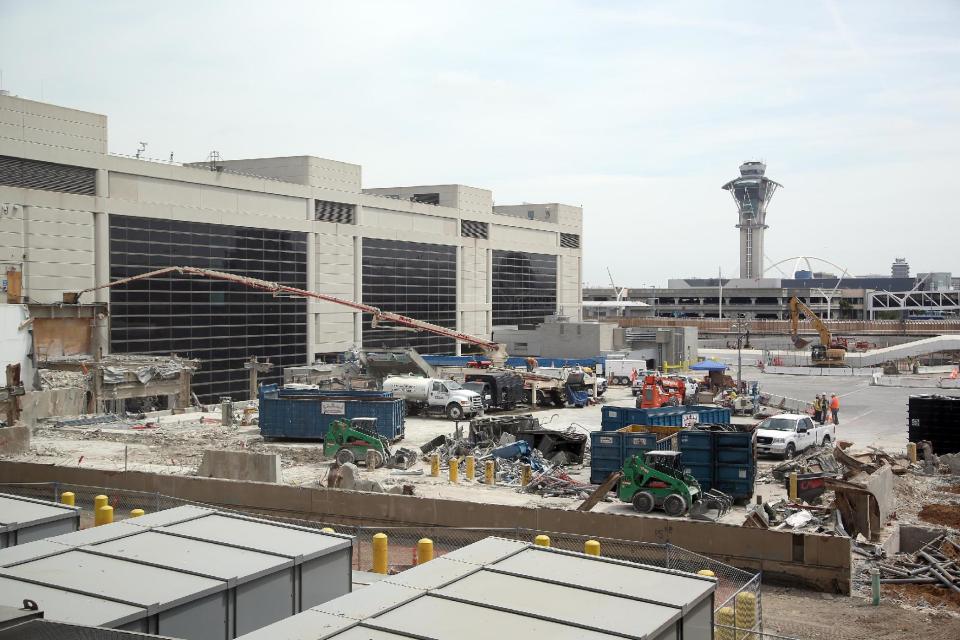 In this May 5, 2014 photo, construction crews work on improvements at Los Angeles International Airport, LAX. An ongoing, multibillion-dollar renovation at the nation's third-busiest airport that has mostly been behind the scenes will soon start affecting passengers in ways large and small. LAX officials began warning the public about the coming inconveniences that will stretch over the next few years and affect traffic around the terminals and passenger movements inside them. (AP Photo/Nick Ut )