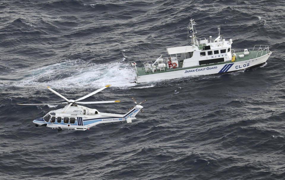 Japanese coast guard helicopter and patrol vessel conduct search and rescue operation in the waters where a U.S. military Osprey aircraft crashed into off the coast of Yakushima Island, Kagoshima prefecture, southern Japan Thursday, Nov. 30, 2023. Japan plans to suspend its own Osprey flights after a U.S. Air Force Osprey based in Japan crashed into waters off the southern coast during a training mission, officials said Thursday. (Kyodo News via AP)