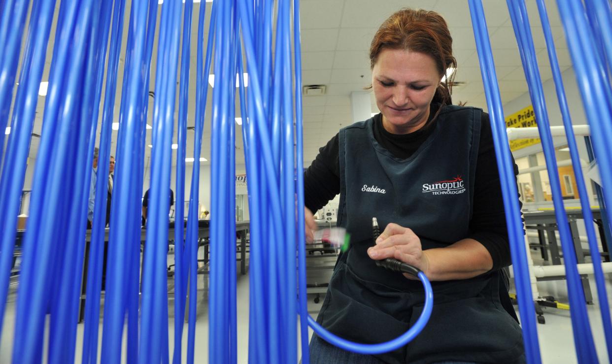 An employee at a Jacksonville technologies 
 company works on an LED fiber optic cable in this 2014 photo.