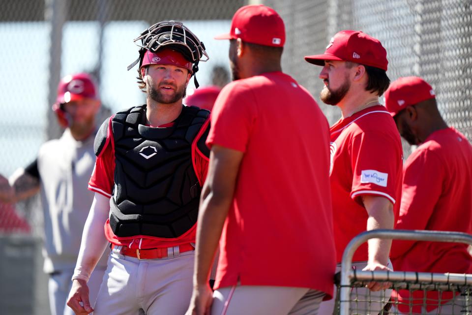 Cincinnati Reds catcher Michael Trautwein talks with Cincinnati Reds starting pitcher Hunter Greene (21) and Cincinnati Reds starting pitcher Graham Ashcraft (51)during spring training workouts, Thursday, Feb. 22, 2024, at the team’s spring training facility in Goodyear, Ariz.