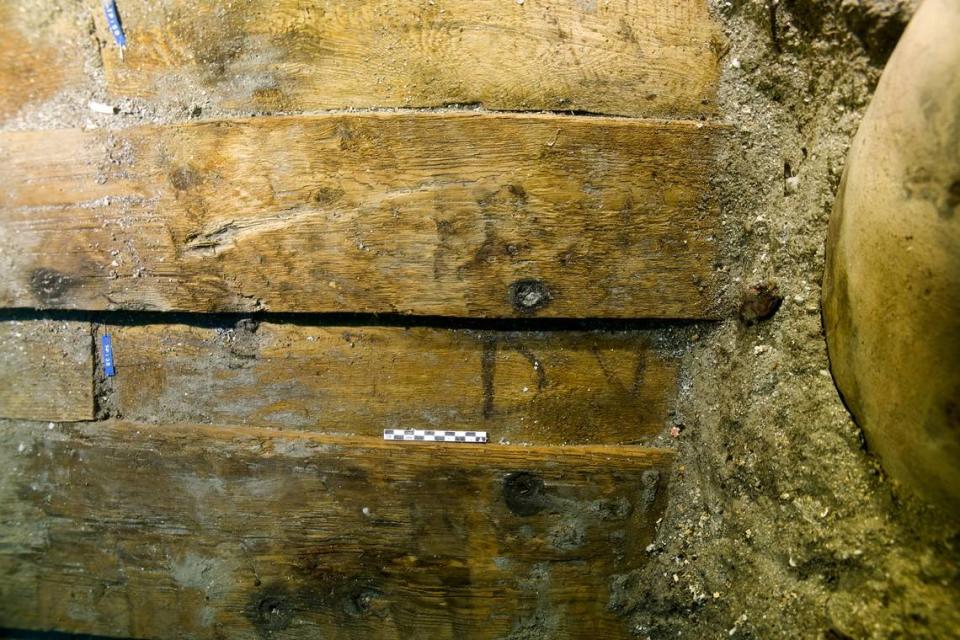 A close-up photo shows the “DV” and “DVI” markings on the planks. Photo from the Catalan Archaeology Museum