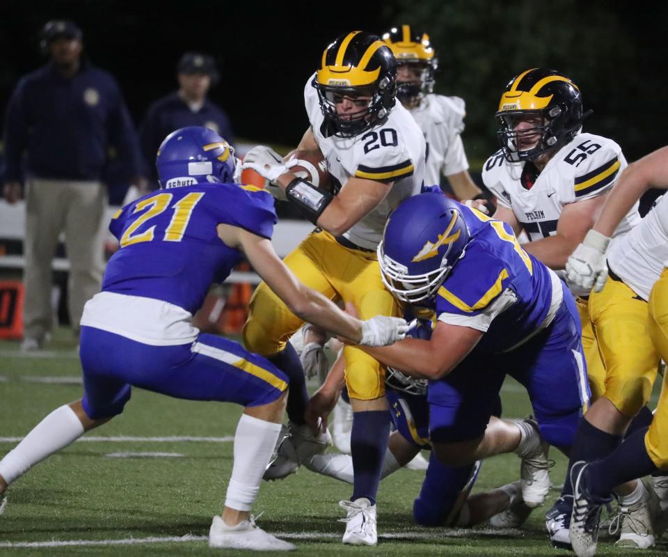 Pelham's Teddy Johnson fights through Mahopac's John Kearney, left, and Danny Koch during their game at Mahopac Sept. 22, 2022. Pelham won 40-34 in OT.