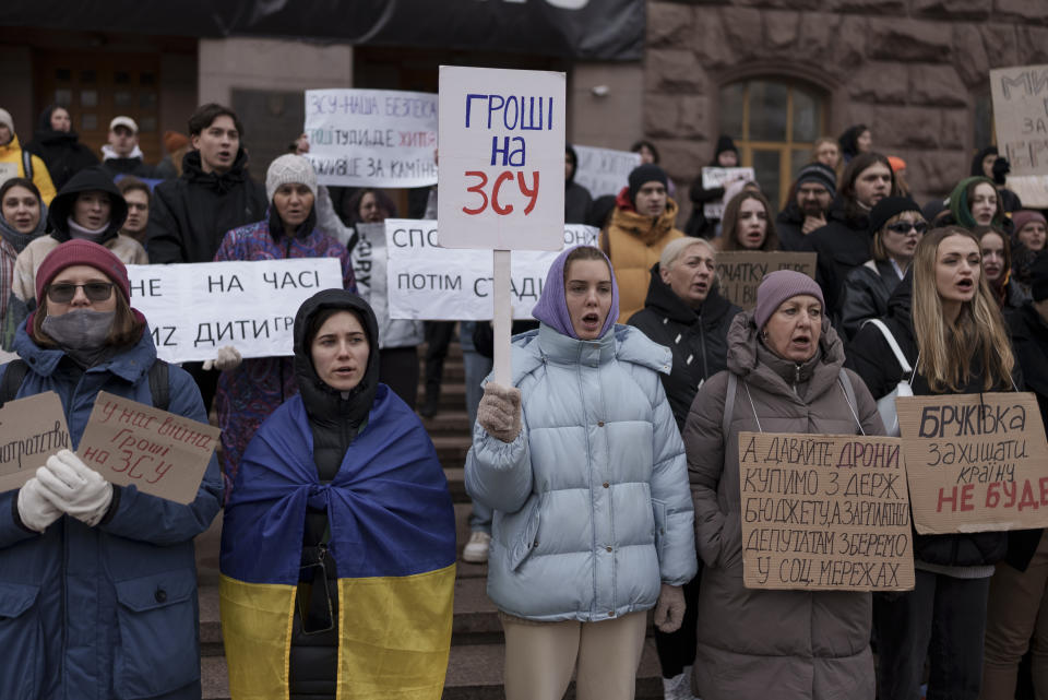 Ukrainians hold banners that read 'Money to the AFU', or Armed Forces of Ukraine, while attending a demonstration in central Kyiv, Ukraine, Saturday, Nov. 18, 2023. People gathered to protest against corruption and demand the reallocation of public funds to the Armed Forces. (AP Photo/Alex Babenko)