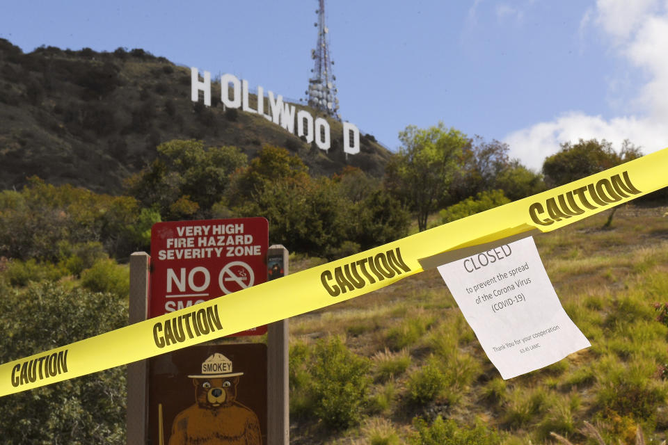 FILE - In this March 28, 2020, file photo a sign is seen at the entrance to Innsdale Trail near the Hollywood Sign in Los Angeles. (AP Photo/Mark J. Terrill, File)