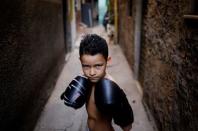 Juan, 7, poses for a photograph in an alley, also known as "viela", in the Mare favela of Rio de Janeiro, Brazil, June 2, 2016. REUTERS/Nacho Doce