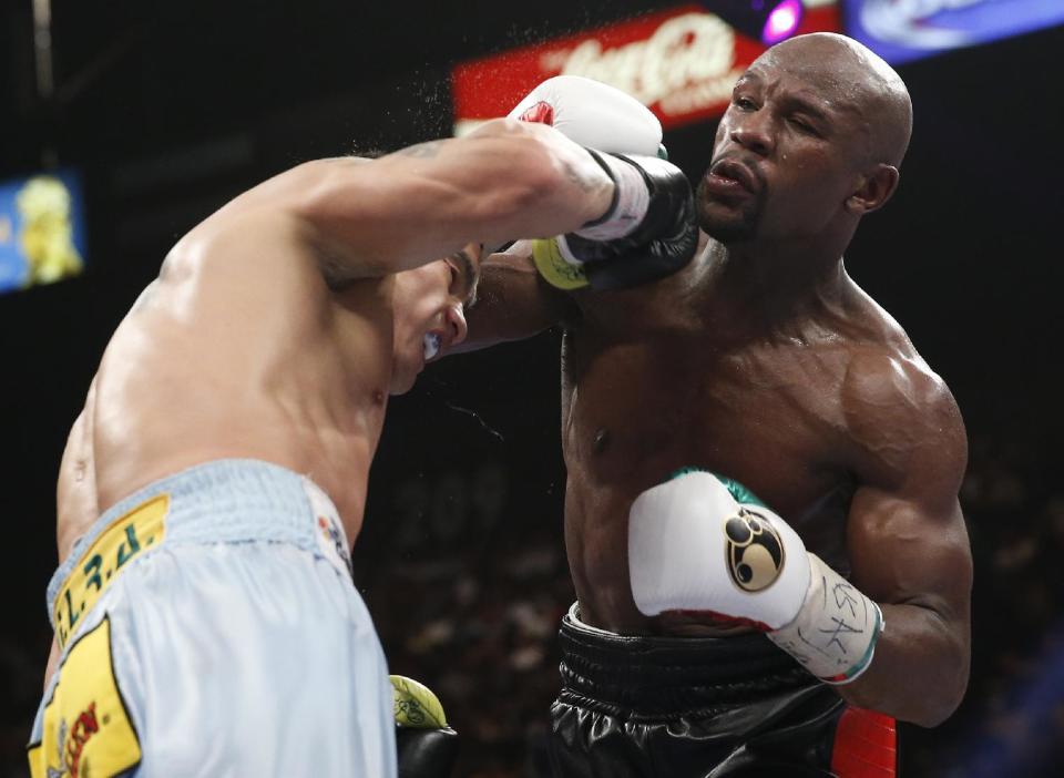 Floyd Mayweather Jr., right, trades punches with Marcos Maidana, from Argentina, in their WBC-WBA welterweight title boxing fight Saturday, May 3, 2014, in Las Vegas. (AP Photo/Eric Jamison)