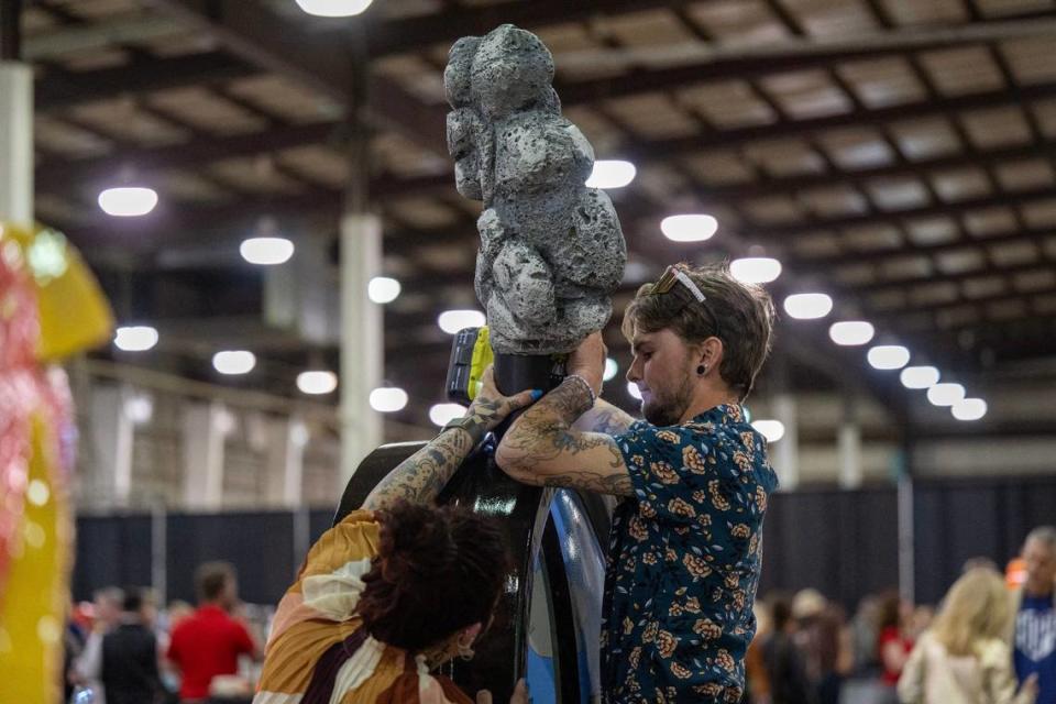 Artist Tayler Peters puts the last finishing touches on his heart titled “Good Eats” Friday during the Parade of Hearts reveal kickoff event. Emily Curiel/ecuriel@kcstar.com