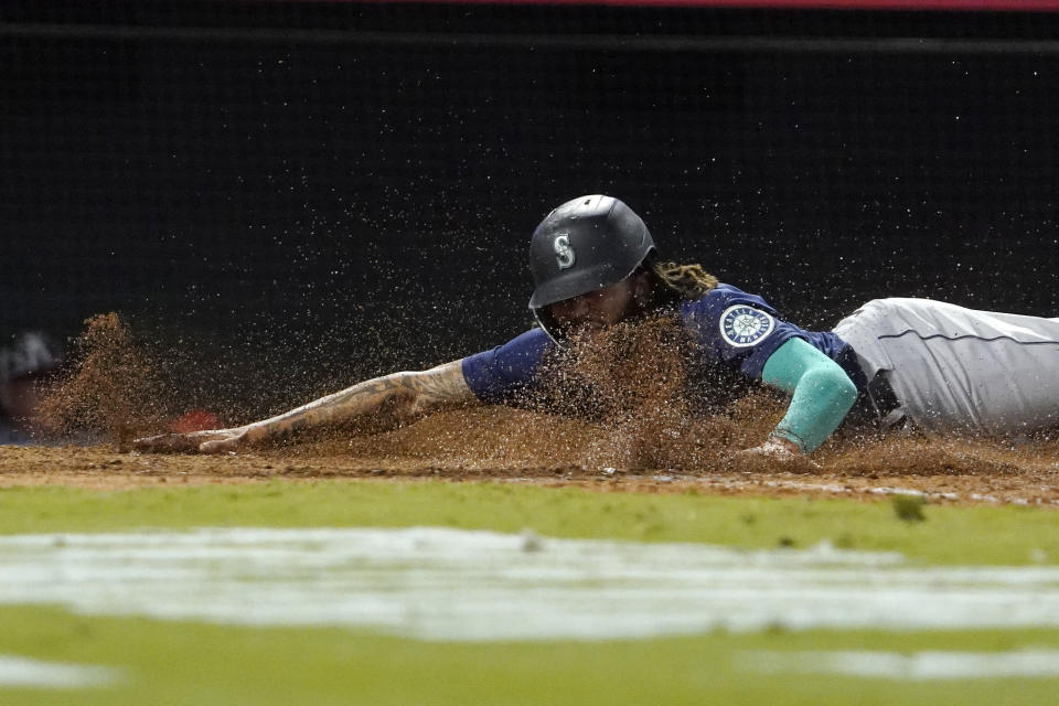 Seattle Mariners' J.P. Crawford scores on a sacrifice fly hit by Mitch Haniger during the seventh inning of a baseball game against the Los Angeles Angels Friday, Sept. 24, 2021, in Anaheim, Calif. (AP Photo/Mark J. Terrill)