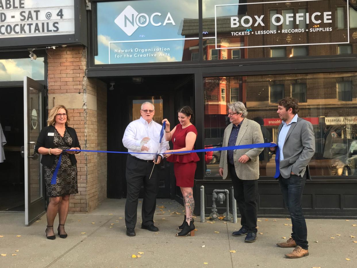 Newark Mayor Jeff Hall and Newark Organization for the Creative Arts Director Angela Smith prepare to ceremoniously cut a ribbon marking the opening of NOCA in downtown Newark on Wednesday, Nov. 17, 2021. Licking County Chamber of Commerce President and CEO Jennifer McDonald (left), and NOCA board members Kirk Homrighouse (center right)  and Tom Atha (right) look on.