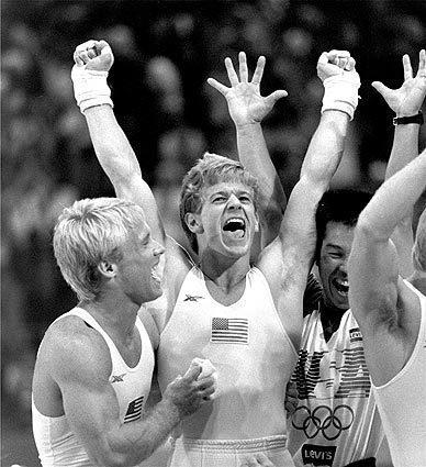 Bart Conner, left, and Peter Vidmar, center, celebrate following the U.S. men's gymnastic team's gold medal.