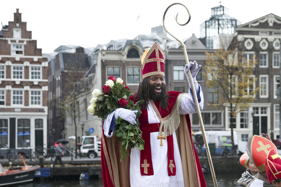 In this Saturday, Nov. 5, 2016, file photo, Sinterklaas, the Dutch version of Santa Claus and traditionally played by a white person, arrives in Amsterdam, Netherlands. As many Dutch children eagerly anticipate the arrival of their country's version of Santa Claus this weekend, opponents and supporters of his controversial helper Black Pete are gearing up for protests. Black Pete is often played by white people with their faces daubed in dark makeup. Supporters see him as a traditional children's character, while opponents decry him as a racist stereotype. (AP Photo/Peter Dejong)