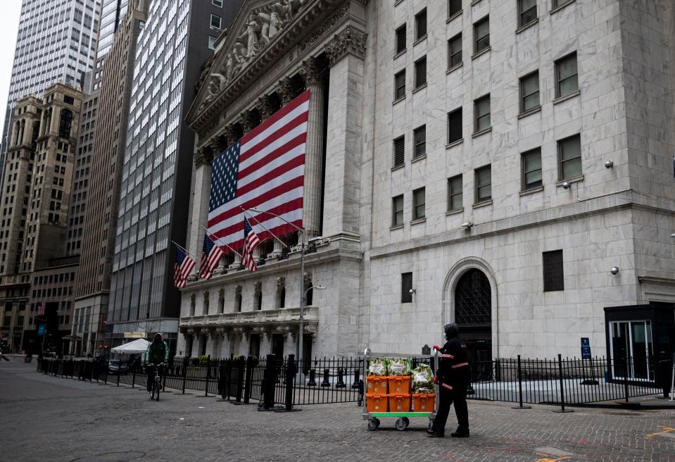 The delivery worker from Amazon's Fresh Direct passes the  New York Stock Exchange (NYSE) on April 20, 2020 at Wall Street in New York City. - Wall Street opened lower on Monday as traders grappled with a drop in oil prices to 22-year lows as the coronavirus pandemic sapped demand for energy. The Dow Jones Industrial Average was down 1.8 percent to 23,798.01 about 10 minutes into the trading session.The broad-based S&P 500 had declined 1.3 percent to 2,835.08, while the tech-rich Nasdaq had fallen 0.7 percent to 8,588.66. (Photo by Johannes EISELE / AFP) (Photo by JOHANNES EISELE/AFP via Getty Images)