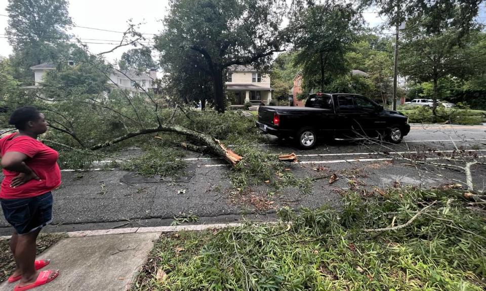 Residents clear tree branches from West Club Blvd at Maryland Ave. in Durham, N.C., on Tuesday, August 15, 2023.