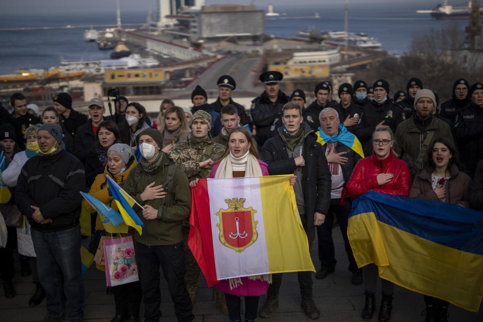 People sing the national anthem as they gather in front of the port to celebrate a Day of Unity in Odessa, Ukraine, Wednesday, Feb. 16, 2022. As Western officials warned a Russian invasion could happen as early as today, the Ukrainian President Zelenskyy called for a Day of Unity, with Ukrainians encouraged to raise Ukrainian flags across the country. (AP Photo/Emilio Morenatti)