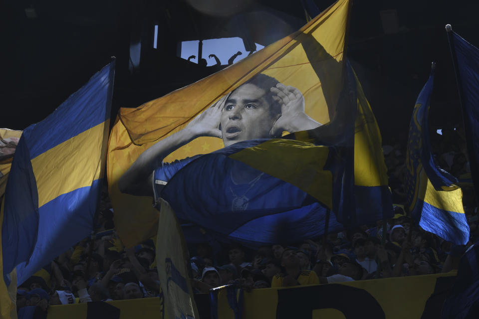 Hinchas de Boca Juniors agitan una manta con la imagen del vicepresidente del club Juan Román Riquelme durante un partido de la liga nacional ante River Plate en La Bombonera de Buenos Aries, el 1 de octubre de 2023 (AP Foto/Gustavo Garello).