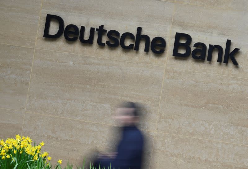 A worker walks past Deutsche Bank offices in London