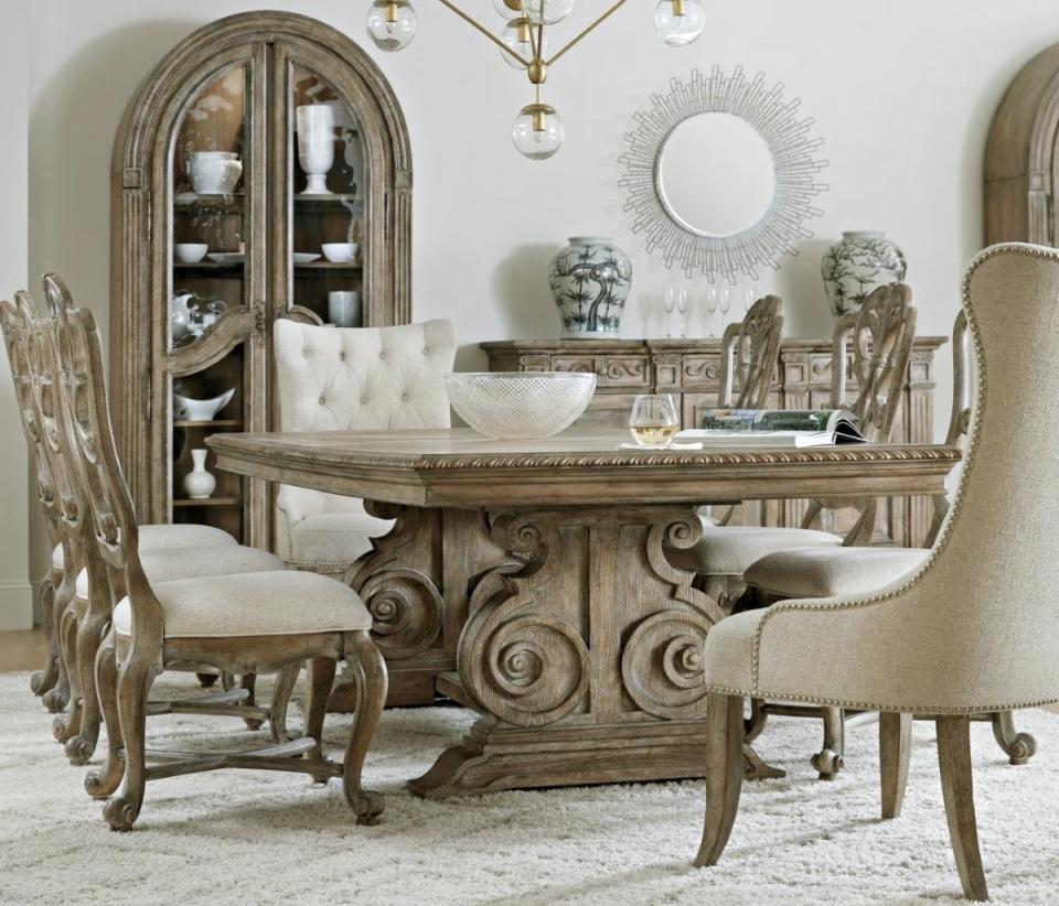 Formal dining room area with large, ornately carved furniture.