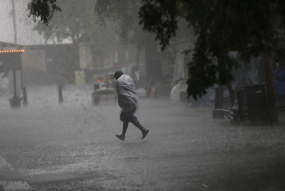 A person runs for shelter in Jackson Square during a heavy downpour on the first day of the annual French Quarter Festival in New Orleans, Thursday, April 11, 2013. French Quarter Festival, which turns 30 this year, runs through Sunday and showcases Louisiana food and music on stages strung throughout the historic neighborhood, including Jackson Square, the French Market, along narrow streets and on the Mississippi riverfront. The lineup includes Irma Thomas, trumpeter Kermit Ruffins, Cajun fiddler Amanda Shaw, the Dirty Dozen Brass Band and about 250 other acts. (AP Photo/Gerald Herbert)