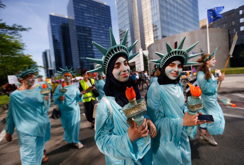 <p>Protesters dressed as the Statue of Liberty march during a demonstration in the center of Brussels on Wednesday, May 24, 2017. Demonstrators marched in Brussels ahead of a visit of President Donald Trump and a NATO heads of state summit which will take place on Thursday. (Photo: Peter Dejong/AP) </p>