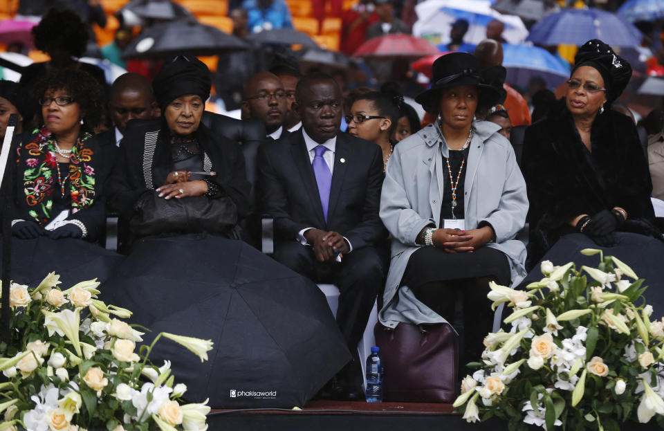 Winnie Madikizela-Mandela, second left, Nelson Mandela's former wife, and Mandela's window Graca Machel, right, listen to speeches during the memorial service for former South African president Nelson Mandela at the FNB Stadium in Soweto near Johannesburg, Tuesday, Dec. 10, 2013. (AP Photo/Matt Dunham)