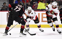 Ottawa Senators right wing Mathieu Joseph (21) controls the puck as Carolina Hurricanes defenseman Brett Pesce (22) uses his skate to take it off his stick, during the second period of an NHL hockey game in Ottawa, Ontario, on Sunday, March 17, 2024. (Justin Tang/The Canadian Press via AP)