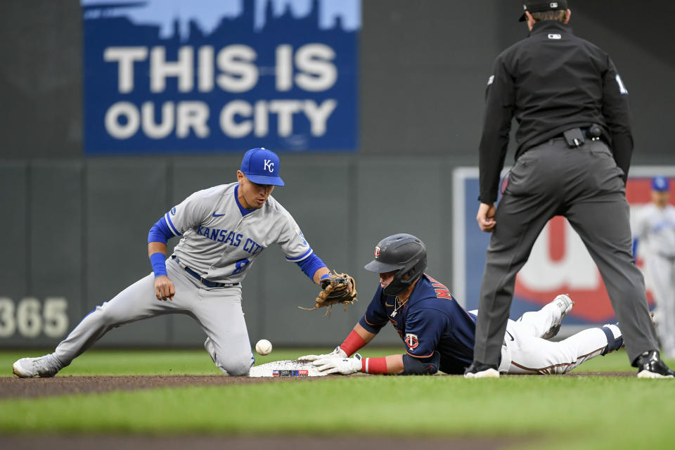 Minnesota Twins' Jose Miranda, center, is safe at second base after hitting a double as Kansas City Royals second baseman Nicky Lopez can't hang on to the ball to make the tag, while umpire Adam Beck watches during the fourth inning of a baseball game Thursday, May 26, 2022, in Minneapolis. (AP Photo/Craig Lassig)