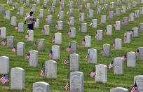 <p>A Boy Scout runs between the grave stones after helping place flags at the Los Angeles National Cemetery on Saturday, May 26, 2018. Thousands of scouts have placed American flags on the graves of veterans in a ceremony ahead of Memorial Day. More than 6,000 children participated in the event. Each uniformed scout placed a flag in the ground by each grave and saluted. Organizers say nearly 90,000 flags were placed in tribute. (Photo: Richard Vogel/AP) </p>