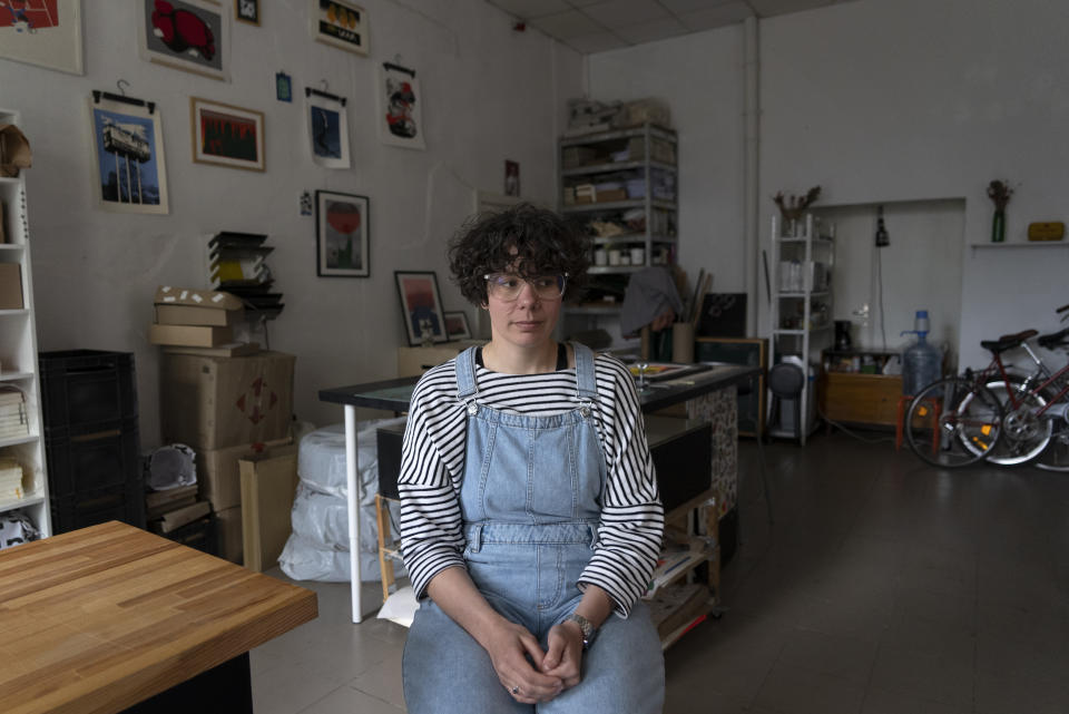 Jenya Polosina, a Kyiv-based artist, is seated in a studio she shares, in Kyiv, Ukraine, Sunday, April 30, 2023. Polosina and artist Anna Ivanenko, not shown, appeared Monday, May 1, 2023, from Kyiv via video link on a screen at an art opening for an exhibit called "Our Fire is Stronger Than Your Bombs" at Saint Anselm College, in Manchester, N.H., Monday, May 1, 2023. Polosina and Ivanenko are among a number of Ukrainian artists with works in the exhibit. (AP Photo/Vasilisa Stepanenko)