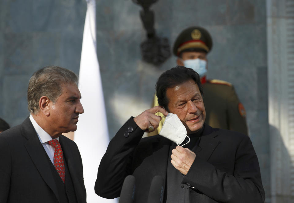 Pakistan Prime Minister Imran Khan removes his face mask during a joint news conference with Afghan President Ashraf Ghani at the Presidential Palace in Kabul, Afghanistan, Thursday, Nov. 19, 2020. (AP Photo/Rahmat Gul)