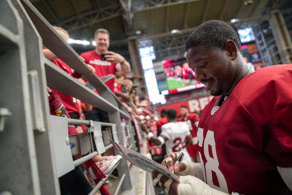 Arizona Cardinals offensive tackle Kelvin Beachum (68) signs autographs during the Arizona Cardinals training camp at State Farm Stadium in Glendale on July 29, 2023.