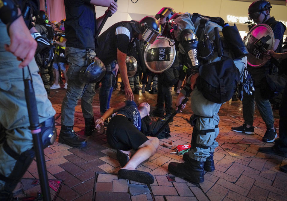 Riot police detain protesters in Central, the main business district in Hong Kong, Sunday, Sept. 8, 2019. Thousands of demonstrators in Hong Kong urge President Donald Trump to “liberate” the semi-autonomous Chinese territory during a peaceful march to the U.S. consulate, but violence broke out later in the business and retail district after protesters vandalized subway stations, set fires and blocked traffic. (AP Photo/Vincent Yu)