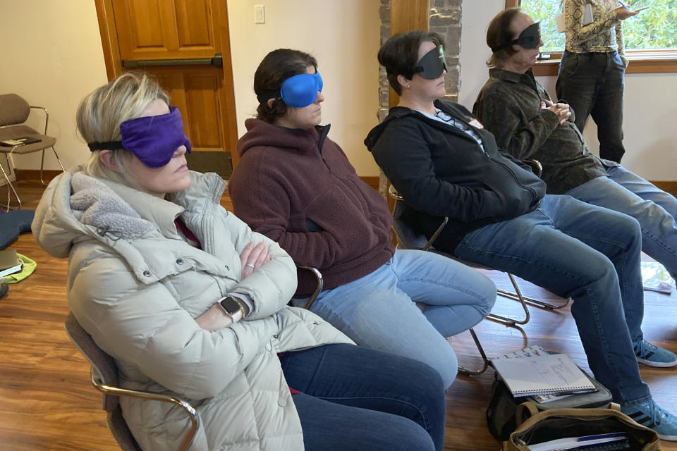 Psilocybin facilitator students sit with eye masks on while listening to music during an experiential activity at a training session near Damascus, Ore., on Dec. 2, 2022. They are being trained in how to accompany patients tripping on psilocybin as Oregon prepares to become the first state in America to offer controlled use of the psychedelic mushroom to the public. (AP Photo/Andrew Selsky)