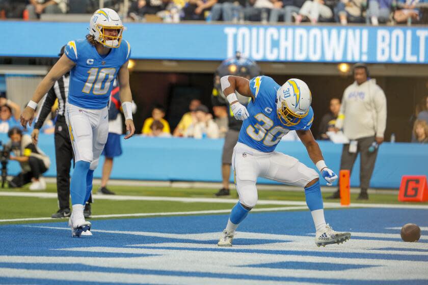 Inglewood, CA, Sunday, January 1, 2022 - Los Angeles Chargers running back Austin Ekeler (30) celebrates with quarterback Justin Herbert after scoring a touchdown against the LA Rams at SoFi Stadium. (Robert Gauthier/Los Angeles Times)