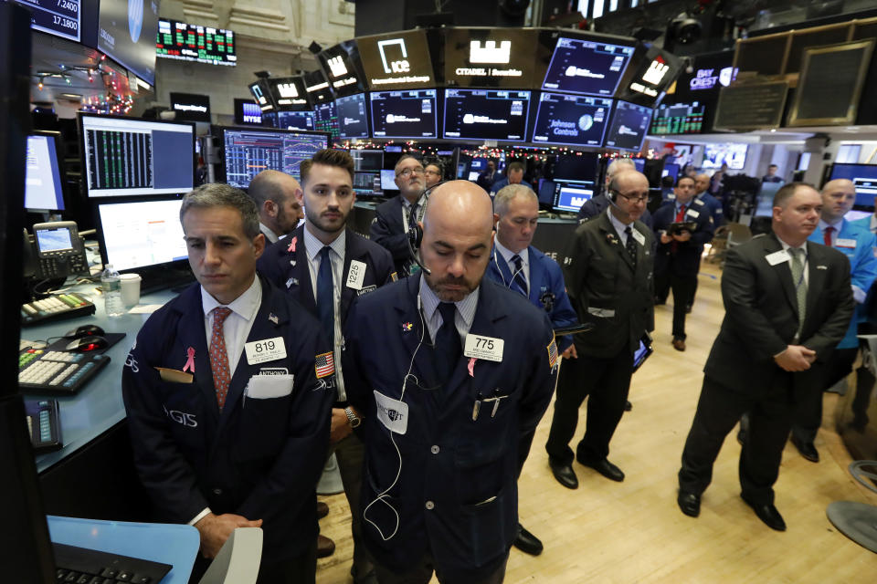 Traders on the floor of the New York Stock Exchange pause for a moment of silence to honor former President George H.W. Bush, Monday, Dec. 3, 2018. (AP Photo/Richard Drew)