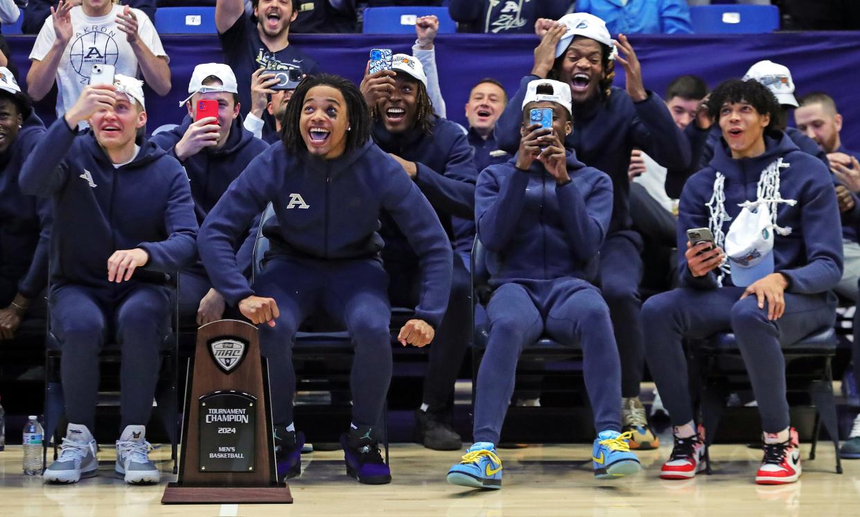 Akron Zips guard Greg Tribble (left center) and forward Enrique Freeman (right) go wild as they find out their fate during the team's watch party for the NCAA Tournament Selection Show at Rhodes Arena on Sunday.