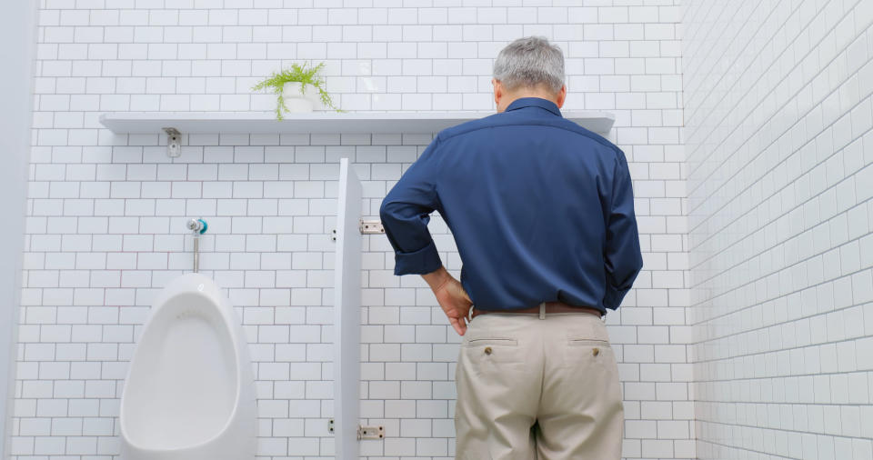 Male genitourinary system diseases concept - asian happy elderly man is peeing smoothly at restroom