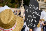 A woman holds a banner reading "Afghan sisters you're not alone" during a demonstration in favor of Afghan women's rights, staged by women rights activists, in Rome, Saturday, Sept. 25, 2021. (AP Photo/Andrew Medichini)