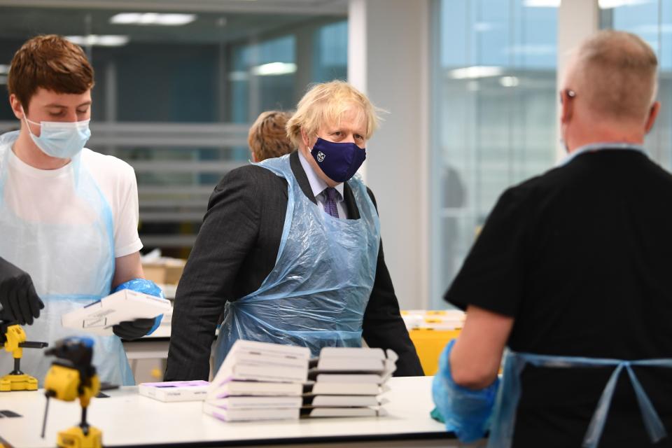 Britain's Prime Minister Boris Johnson (C) wears PPE (Personal Protective Equipment) as he visits the Lighthouse Laboratory used for processing PCR samples at the Queen Elizabeth University Hospital campus in Glasgow, Scotland on January 28, 2021, during a COVID-19 related visit to the country. - Prime Minister Boris Johnson headed to Scotland on Thursday to praise the United Kingdom's collective response to coronavirus, in a bid to counter record support for independence. (Photo by Jeff J Mitchell / POOL / AFP) (Photo by JEFF J MITCHELL/POOL/AFP via Getty Images)