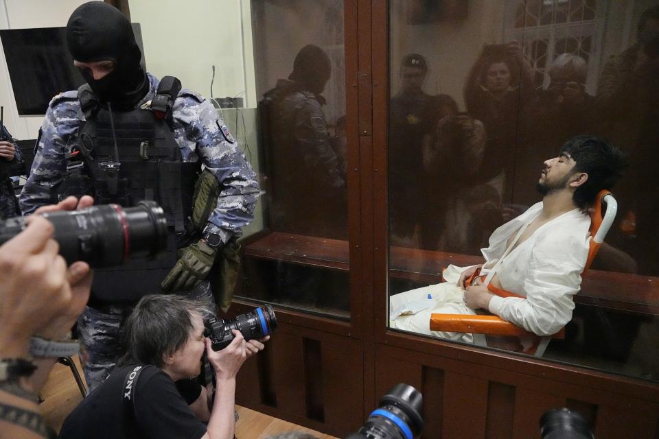 FILE - Mukhammadsobir Faizov, a suspect in the Crocus City Hall shootings, sits in a defendants’ cage in Basmanny District Court in Moscow, Russia, on March 24, 2024. The attack on the Moscow concert hall, the bloodiest assault on Russian soil in two decades, appears to be setting the stage for an increasingly harsh response by President Vladimir Putin. Four suspects in the attack appeared in court showing signs of brutal treatment while in custody. (AP Photo/Alexander Zemlianichenko, File)