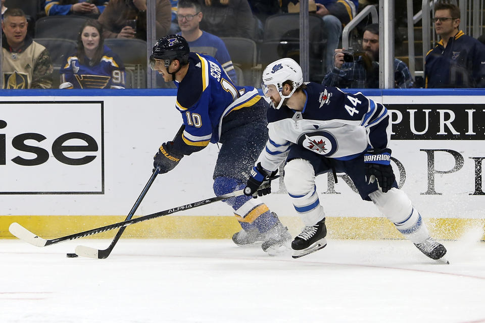 St. Louis Blues' Brayden Schenn (10) handles the puck past Winnipeg Jets' Josh Morrissey (44) during the second period of an NHL hockey game Thursday, Feb. 6, 2020, in St. Louis. (AP Photo/Scott Kane)